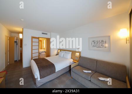 MONTE CARLO, MONACO - 3. August 2016: Novotel Hotel, schöne Einrichtung des Hotelzimmers, Schlafzimmer mit Aussicht, Sofa, Bad Stockfoto