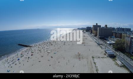 Am sonnigen Sommertag erholen sich viele Menschen am Brighton Beach. Luftaufnahme Stockfoto
