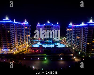 ALANYA, TÜRKEI - 16. August 2015: Drei Gebäude des Wohnkomplexes Azura Park Residence mit Farblicht bei Nacht, Luftbild Stockfoto