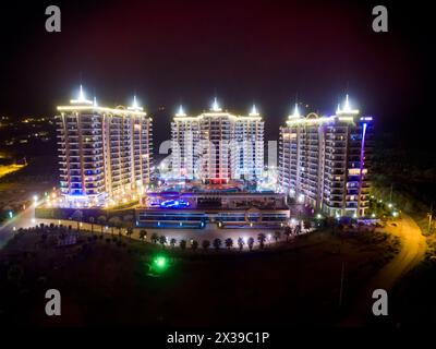 ALANYA, TÜRKEI - 16. August 2015: Drei Gebäude des Wohnkomplexes Azura Park Residence mit Farblicht bei Nacht, Luftbild Stockfoto