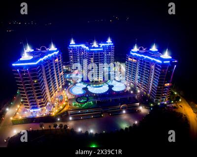 ALANYA, TÜRKEI - 16. August 2015: Drei Gebäude des Apartmentkomplexes Azura Park Residence mit Farblicht bei Nacht, Luftbild Stockfoto
