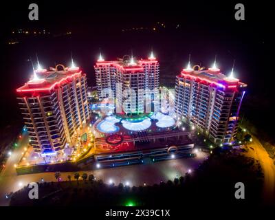 ALANYA, TÜRKEI - 16. August 2015: Drei Gebäude des Apartmentkomplexes Azura Park Residence mit rotem Licht bei Nacht, Luftbild Stockfoto