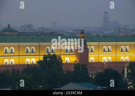 Teil des Arsenalgebäudes und der roten Kreml-Mauer mit nächtlicher Belebung in Moskau, Russland Stockfoto