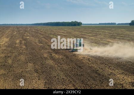 REGION KRASNODAR, RUSSLAND - 19. August 2015: Moderner grüner Traktor pflügt das Feld nach der Ernte, im Jahr 2015 erreichte der Ertrag in der Region Krasnodar ein Rekordniveau - Stockfoto