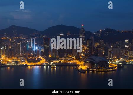 Wolkenkratzer mit Beleuchtung, Uferfront und Berge in Hongkong, China bei dunkler Nacht, Blick vom New World Center Stockfoto