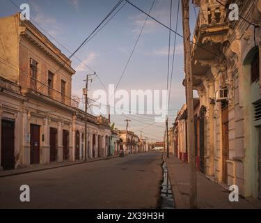 Blick auf eine verlassene Straße in der Innenstadt von Cienfuegos, Kuba, kurz vor Sonnenaufgang. Stockfoto