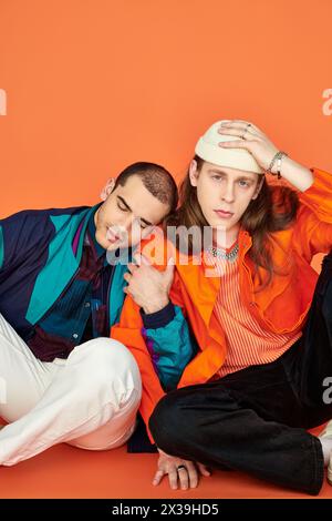 Zwei junge Männer, ein attraktives, liebevolles schwules Paar, sitzen dicht nebeneinander. Stockfoto