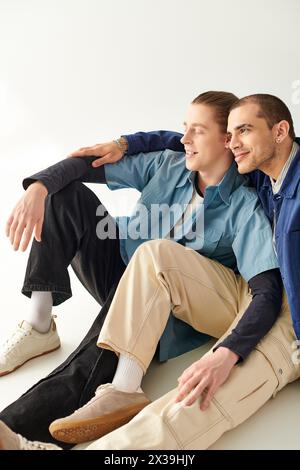 Zwei Männer sitzen dicht auf dem Boden und strahlen Wärme und Kameradschaft aus. Stockfoto