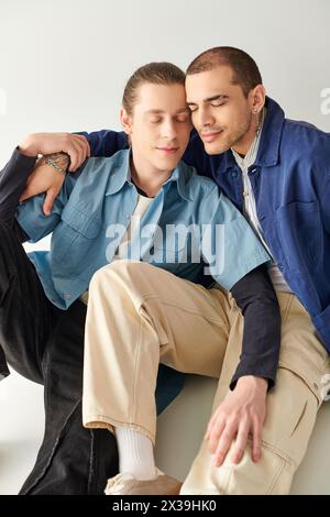 Zwei junge Männer sitzen eng zusammen und teilen einen Moment der Verbindung. Stockfoto