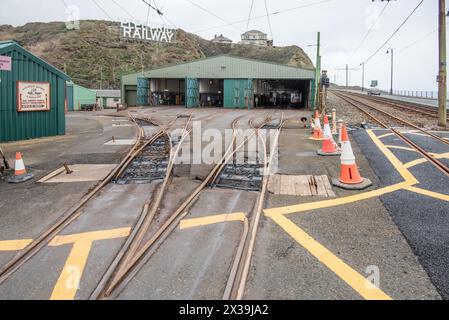 ELEKTRISCHES EISENBAHNSCHILD der Manx Electric Railway hoch oben auf einer Felswand an einer markanten Position. Unten sind die Schuppen und ein Muster von sich kreuzenden Linien. Stockfoto