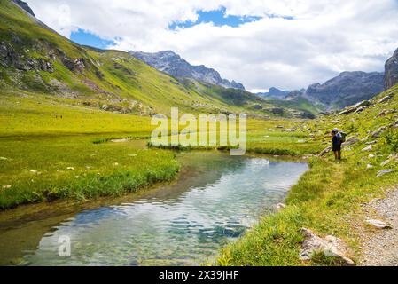 Ein paar Wanderer auf einem wunderschönen Alpinpfad im Bergtal in der Nähe des Baches, der zum See La Plagne in den französischen Alpen führt. Peisey Valley, Savoie, Frankreich. Stockfoto