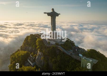 Rio de Janeiro, Brasilien - 11. April 2024: Dramatischer Blick auf die Christus-Erlöser-Statue auf dem Berg Corcovado über Wolken bei Sonnenaufgang. Stockfoto