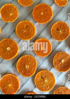 Mandarinen schneiden in Scheiben. Auf Lebensmittelpapier gelegt. Zum Trocknen und Dekorieren von Desserts. Stockfoto