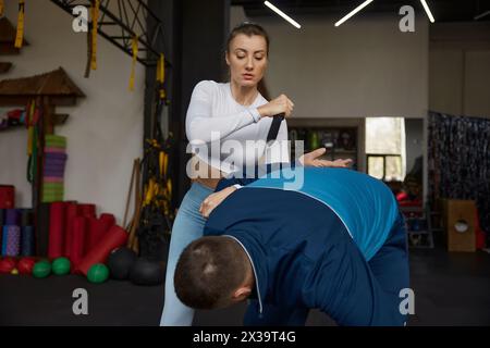 Junge sportliche Frau, die mit Messerwaffe mit Trainer trainiert Stockfoto