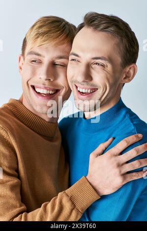 Zwei lächelnde Männer in lässiger Kleidung, die sich warm umarmen. Stockfoto