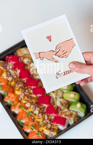 Sushi-Rolle (Philadelphia) mit Lachs, geräuchertem Aal, Avocado, Frischkäse auf schwarzem Hintergrund. Sushi-Menü. Japanisches Essen Stockfoto