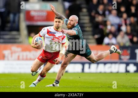 Tommy Makinson (links) wird von Huddersfield Giants Jake Bibby während des Spiels der Betfred Super League im Totally Wicked Stadium in St Helens angegriffen. Bilddatum: Donnerstag, 25. April 2024. Stockfoto