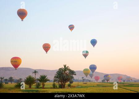 Farbenfrohe Heißluftballons starten bei Sonnenaufgang vom Westufer von Luxor, Ägypten Stockfoto