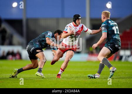 St Helens' Jonny Lomax (Mitte) geht an Huddersfield Giants' Leroy Cudjoe (links) während des Spiels der Betfred Super League im Totally Wicked Stadium in St Helens vorbei. Bilddatum: Donnerstag, 25. April 2024. Stockfoto