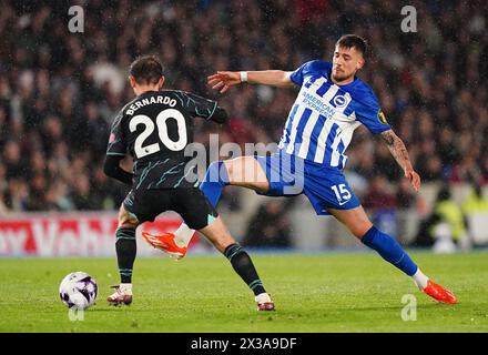 Bernardo Silva von Manchester City und Jakub Moder von Brighton und Hove Albion kämpfen um den Ball während des Premier League-Spiels im American Express Stadium in Brighton. Bilddatum: Donnerstag, 25. April 2024. Stockfoto