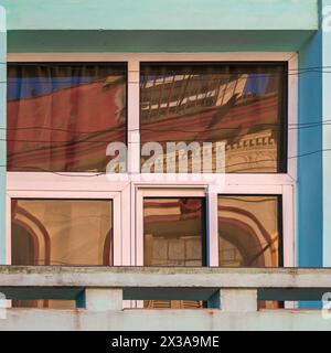 Gebäude im alten Stil spiegeln sich in den Fenstern moderner Gebäude auf der anderen Straßenseite wider. Stockfoto