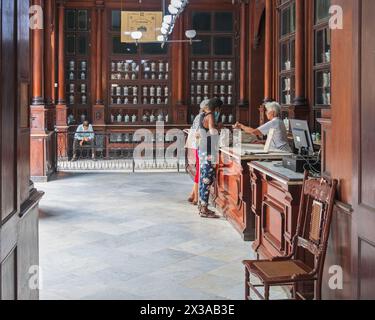 Das Apothekenmuseum mit seinen Holzregalen voller französischer Apothekergläser aus dem 19. Jahrhundert ist heute noch eine arbeitende Apotheke in der Altstadt von Havanna, Kuba Stockfoto