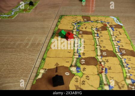 Mozyr, Weißrussland, 03. April 2024: Brettspiel carcassonne für einen familienfreundlichen Abend. Meeples auf dem Tablet, um den Fortschritt der Spieler zu berechnen Stockfoto