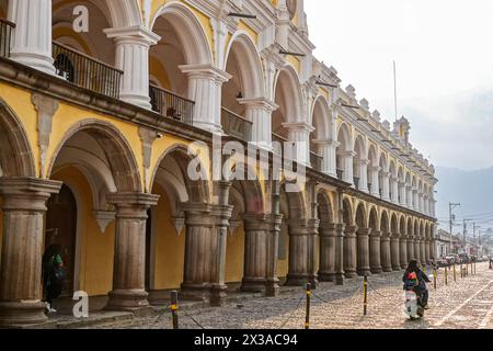 Ein Motorrad passiert das Nationalmuseum für guatemaltekische Kunst im historischen Hauptpalast auf dem zentralen platz in Antigua, Guatemala. Stockfoto