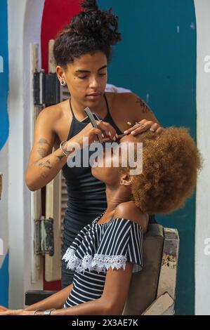 Eine junge Frau, die ihre Haare in einem Friseur in der Altstadt von Havanna, Kuba frisiert Stockfoto