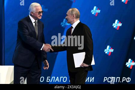 Moskau, Russland. April 2024. Der russische Präsident Wladimir Putin, rechts, wird vom Präsidenten der Russischen Union der Industriellen und Unternehmer Alexander Shochhin, links, begrüßt, bevor er eine Ansprache auf dem Jahreskongress der RSPP am 25. April 2024 in Moskau hält. Quelle: Alexander Kazakov/Kreml Pool/Alamy Live News Stockfoto