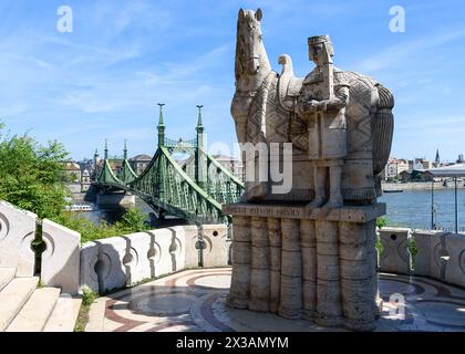 Die Statue des Heiligen Stephan am Fuße des Gellert-Hügels mit der Freiheitsbrücke im Hintergrund Stockfoto