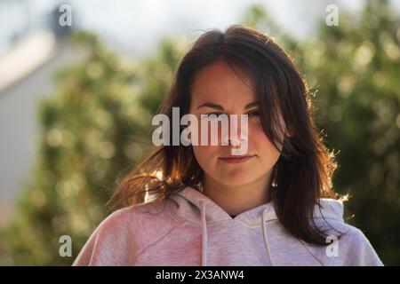 Porträt einer jungen brünetten Frau in einem rosa Hoodie Stockfoto