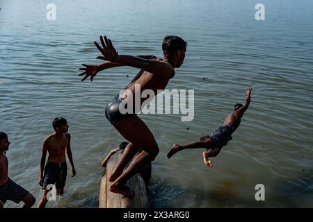 26. April 2024, Kolkata, Westbengalen, Indien: Jungen springen während einer schweren Hitzewelle in den Ganges. Schwere Hitzewellen-Warnung durch das India Meteorological Department (IMD) in einigen Distrikten im südlichen Teil von Westbengalen, Indien. Am 25. April 2024 lag die höchste Temperatur bei 42 Grad Celsius, was etwa 6 Grad höher war als der Normalwert. IMD-Experten sagten auch, dass dies bis zum 28. April 2024 fortgesetzt werde, da der Wind auf niedrigem Niveau weiterhin von West- und Nordwestindien über die Region weht. Die extreme Hitze wird für die Leute unerträglich Stockfoto