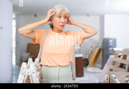 Frau unzufrieden mit dem Ergebnis der Reparaturarbeiten Stockfoto