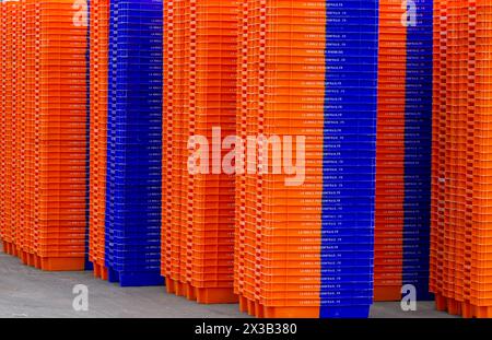 Stapel neuer Kunststoff-Fischboxen in Farbe oder Farbe Orange und Blau Streifen Stockfoto