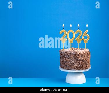 Kuchen mit 2026 Kerzen auf blauem Hintergrund Stockfoto