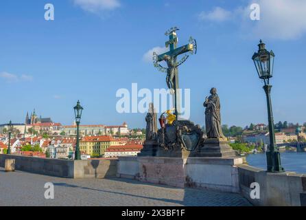 Statue des Heiligen Kreuzes und des Kalvariums auf der Karlsbrücke in Prag, Tschechien, an sonnigen Tagen Stockfoto