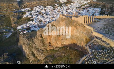 Drohnenaufnahme, erstes Morgenlicht, Lindos, Akropolis von Lindos, Luftaufnahme der Akropolis von Lindos auf einer Klippe über der Stadt im Abendlicht Stockfoto