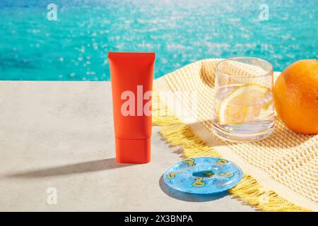 Das Konzept der Sommerzeit mit unbeschriftetem rotem Röhrchen, verziert mit einer Mini-Schwimmboje, einer Tasse Entgiftungswasser und Orange. Unbeschriftetes Etikett für natürliche Schönheit Stockfoto