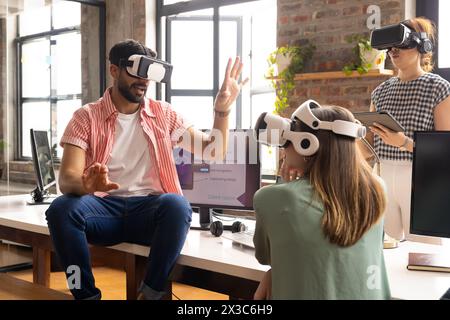 Ein vielseitiges Team von VR-Headsets erkundet den digitalen Raum in einem modernen Büro Stockfoto