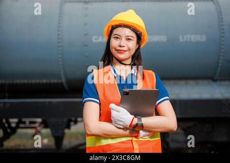 Portrait-Lokomotivingenieur weibliche Arbeiter. Junge asiatische Teenager glücklich lächelnd viel Spaß bei der Arbeit prüfen Service Wartung Zug mit Tablet. Stockfoto