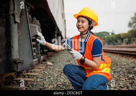 Lokomotivingenieur weibliche Arbeiter. Junge Teenager Asiatische Arbeitsüberprüfung Service Wartung Zug mit Tablet Computer Software. Stockfoto