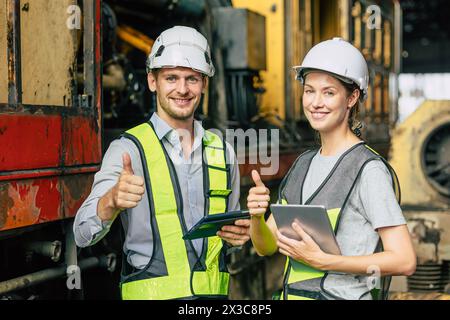 Ingenieurbüro für Zugmaschinen, Männer und Frauen, die bei Mitarbeitern der Lokomotivindustrie zusammenarbeiten Stockfoto