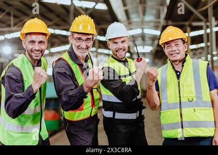 Ein männliches Ingenieurteam, das in der Schwerindustrie arbeitet, steht zusammen. Eine Gruppe professioneller Mitarbeiter arbeitet glücklich und selbstbewusst zusammen. Stockfoto