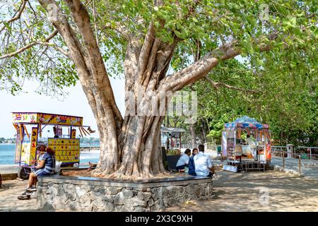 Cochin, Indien - 22. März 2024: Menschen an der Promenade in Kochi, Indien, mit Händlern, die Süßigkeiten, Speisen und Getränke verkaufen. Stockfoto