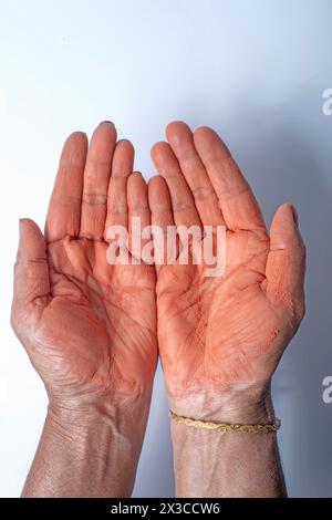 Hände einer Indianerin mit rotem holi-Pulver auf Hand isoliert auf weißem Hintergrund. Draufsicht Stockfoto