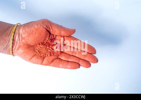 Hände einer indischen Frau mit holi-Pulver in der Hand isoliert auf weißem Hintergrund. Draufsicht Stockfoto