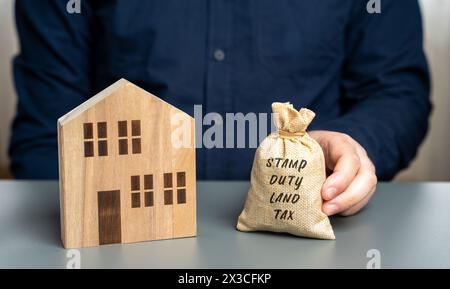 STAMP Duty Landsteuer SDLT Konzept. Steuern, die während der Übertragung von Immobilien zwischen zwei Parteien erhoben werden. Kauf von Wohnungen und Grundstücken. Geldbeutel im han Stockfoto