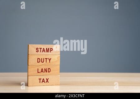 STAMP Duty Landsteuer SDLT Konzept. Steuern, die während der Übertragung von Immobilien zwischen zwei Parteien erhoben werden. Kauf von Wohnungen und Grundstücken. Eigenschaft. Holzblo Stockfoto