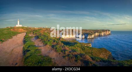 Der Sonnenaufgang am frühen Morgen scheint auf den zerklüfteten Klippen des Flamborough Lighthouse und auch auf dem alten Chalk Lighthouse in der Ferne. Stockfoto